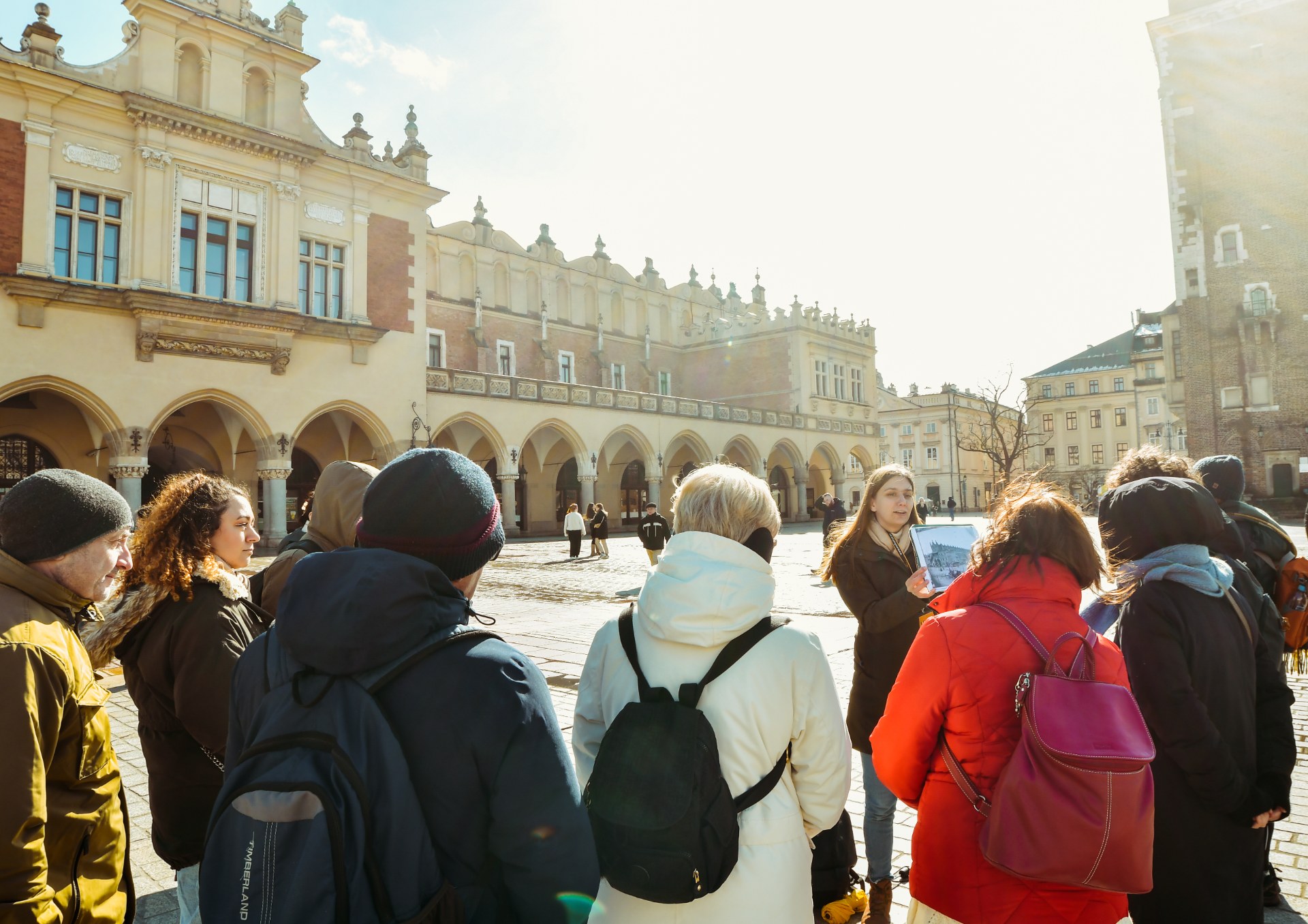 Eine Gruppe junger Menschen mit Stadtführer auf dem Hauptmarkt in Krakau